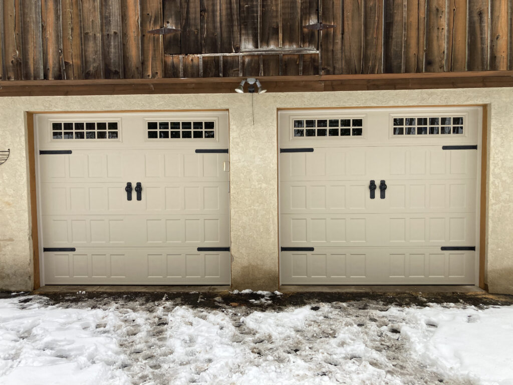 short panel traditional garage doors with black handles and hinges.