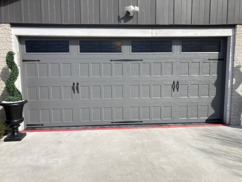 Grey garage door with spade shaped hinges and handles